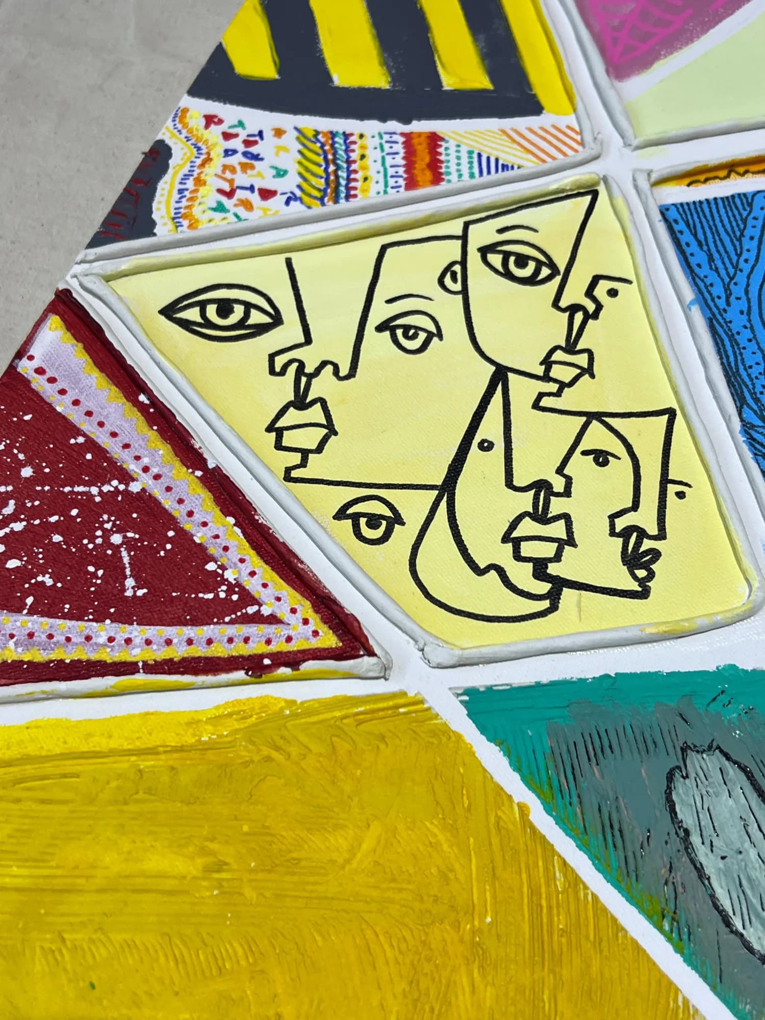 Faces drawn into the panels of the shared canvas