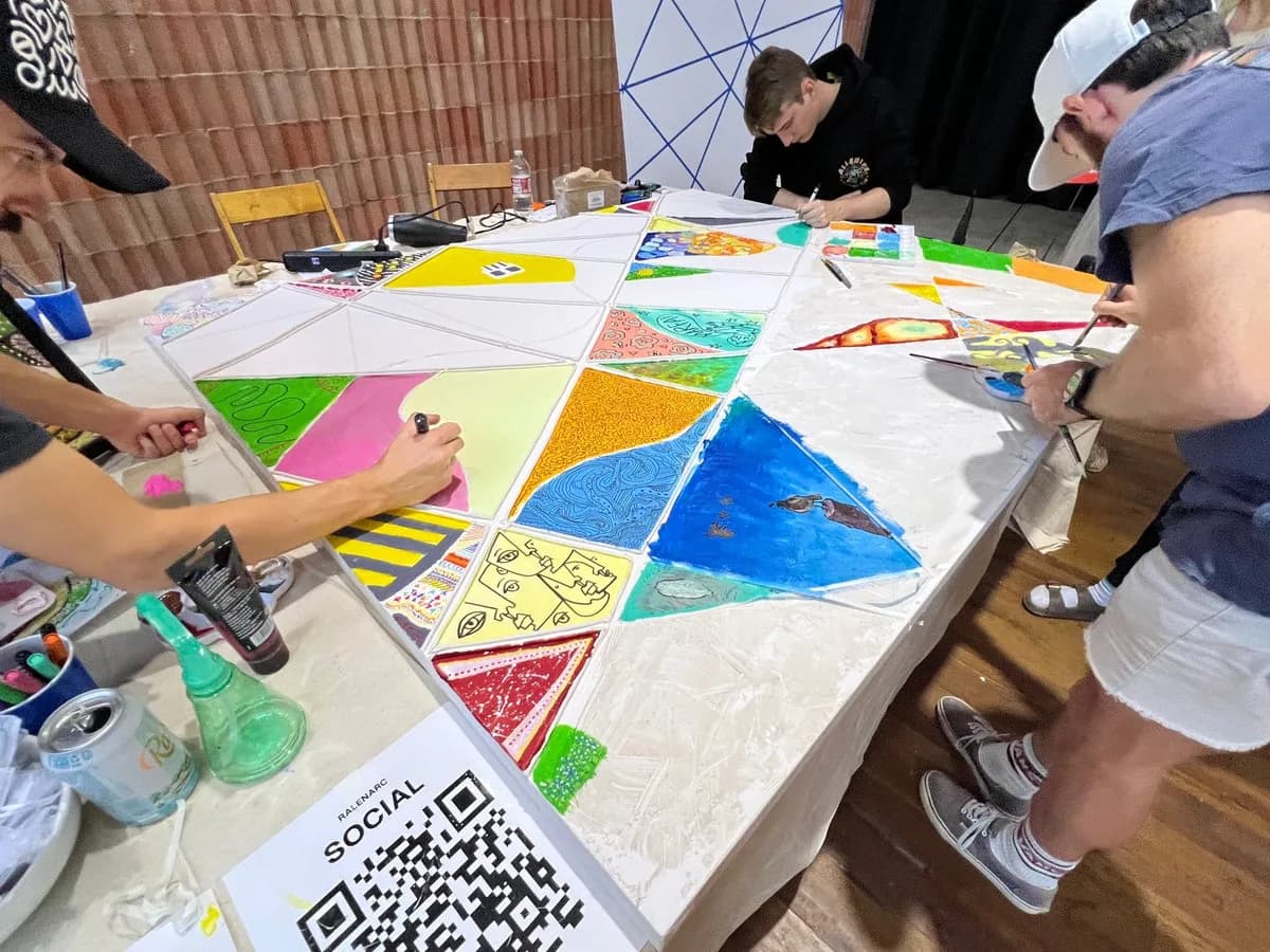 Attendees painting their panels at the shared table