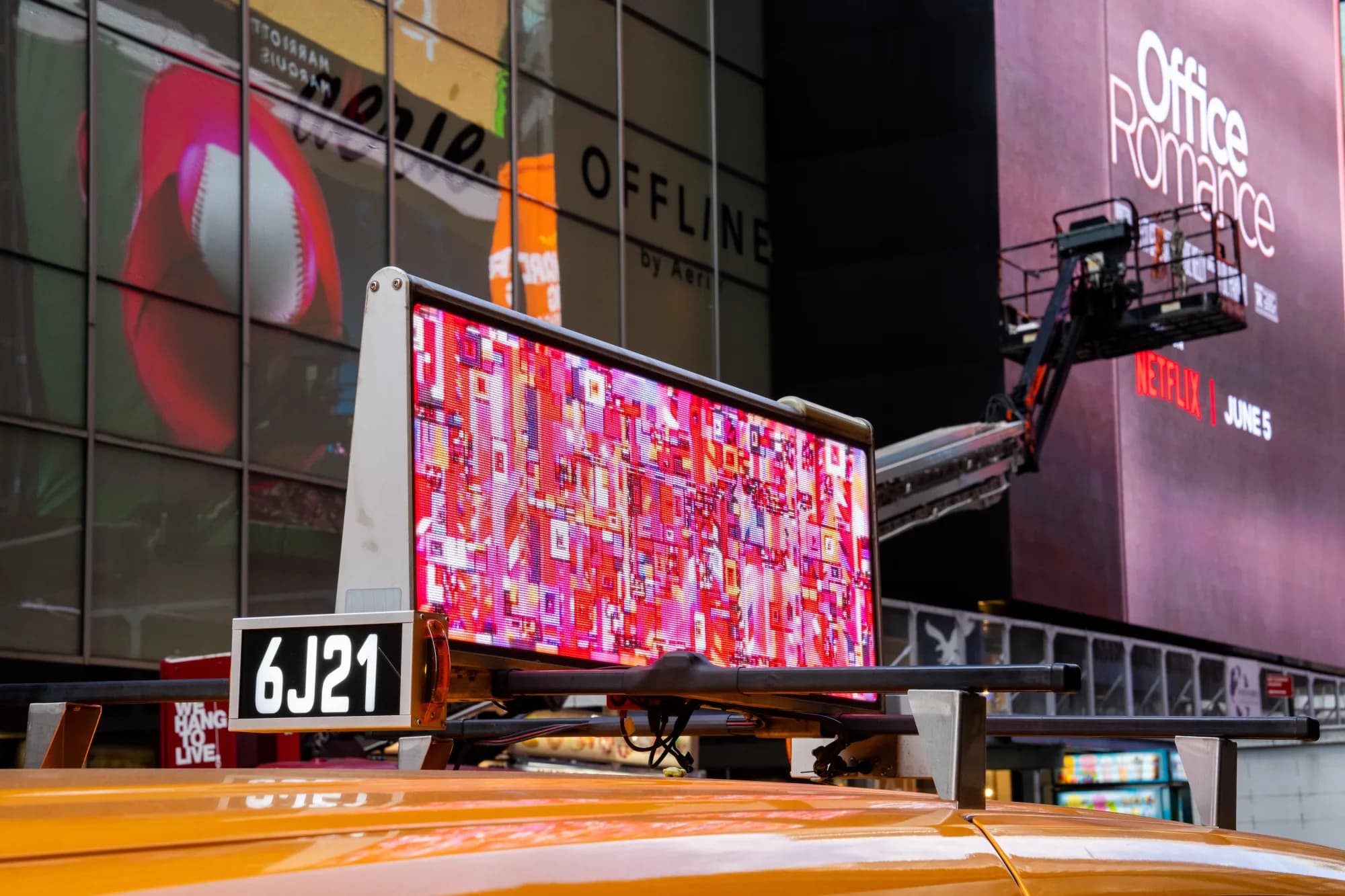 Pink RalenArc artwork displayed on a taxi in Times Square